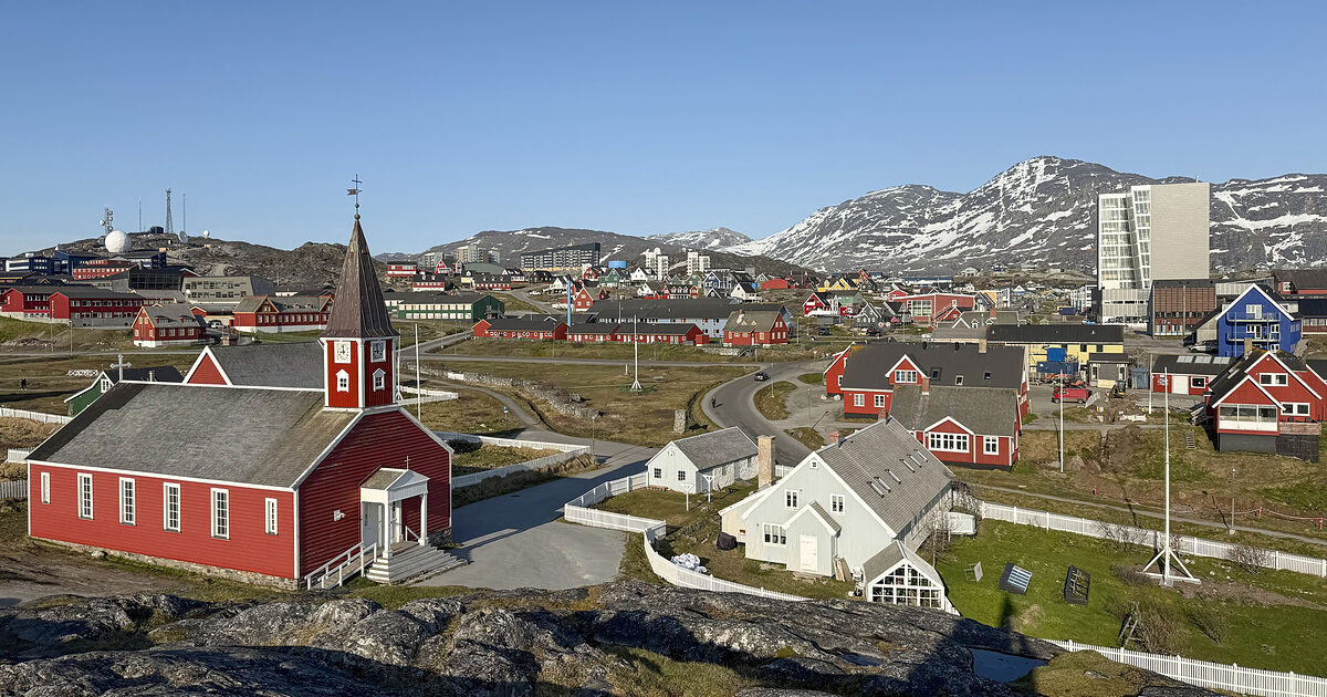 Nuuk i Grønland med den gamle kirke, farvede træhuse og snedækkede fjelde bagved